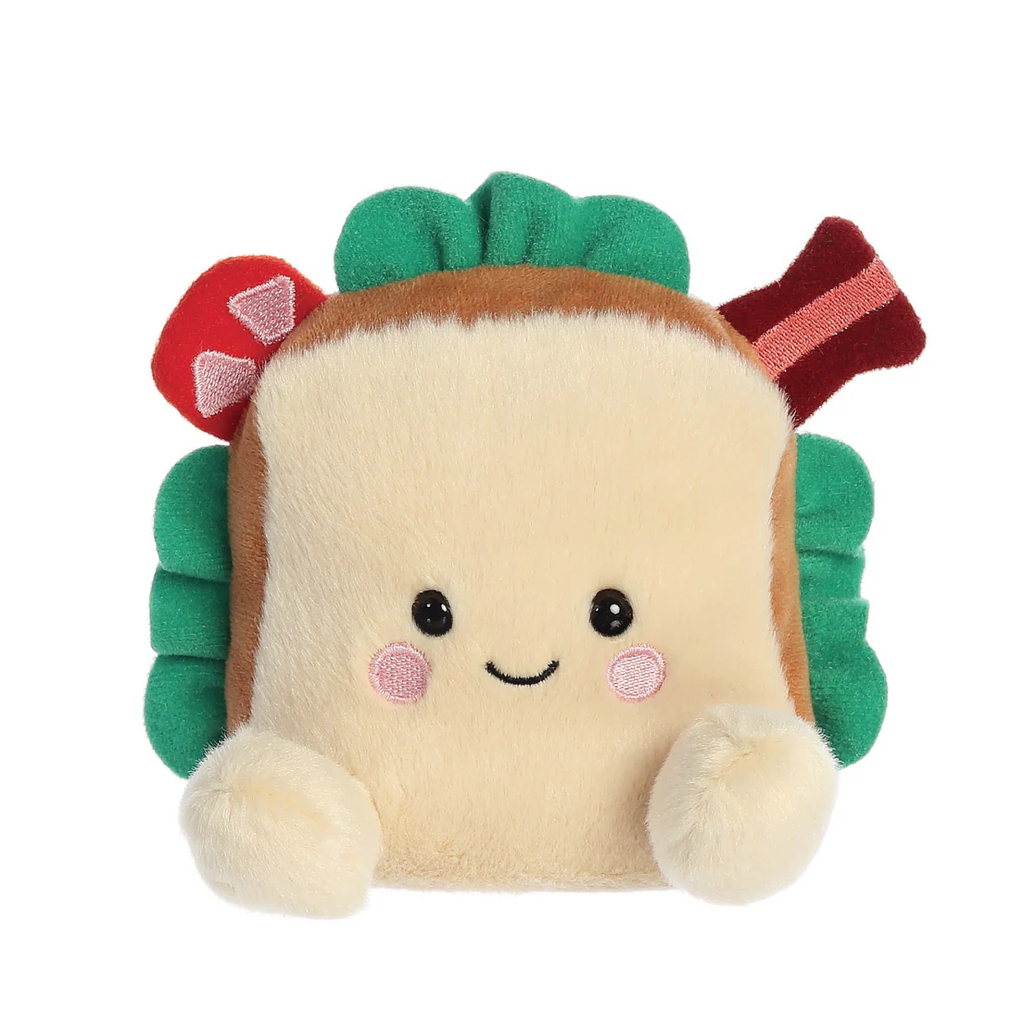 soft toy in the shape of a BLT, named Tomas BLT Soft Toy. He has a friendly smilimg face and pink cheeks, with green lettuce, red tomato and streaky bacon peeking out from the bread 